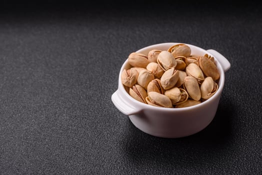 Delicious nutritious pistachio nuts in ceramic bowl photo