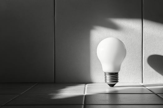 Unique light bulb casting shadows on a colorful wall in a modern interior setting photo
