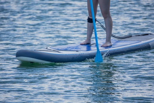 closeup Young Woman Paddleboarding on Lake During Summer photo