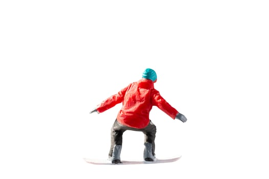 Miniature figurine depicting a snowboarder in mid-motion isolate on white background with clipping path photo