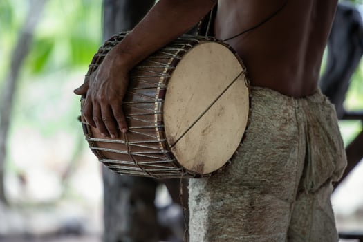 Closeup of Wayuri indigenous community member playing traditional drum in Ecuadorian Amazon photo