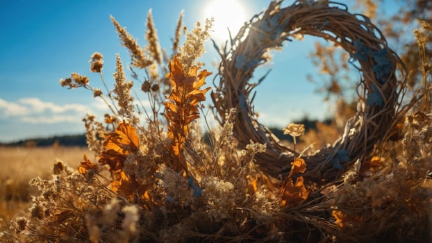 A rustic wreath surrounded by autumn foliage in a sunlit field. photo