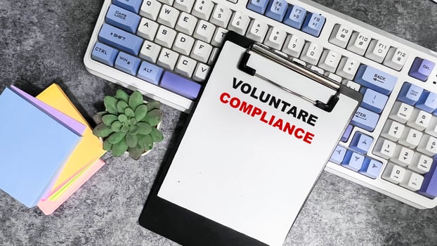 Concept of Voluntare Compliance write on paperwork isolated on Wooden Table. photo