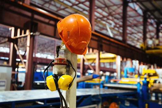 Helmet and ear-phones on blurred industrial background photo