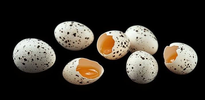 Spotted Quail Eggs Broken and Whole on Black Background photo
