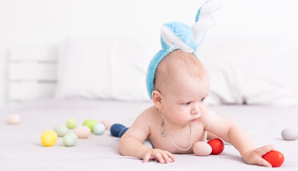 happy baby child with Easter bunny ears and colorful eggs photo