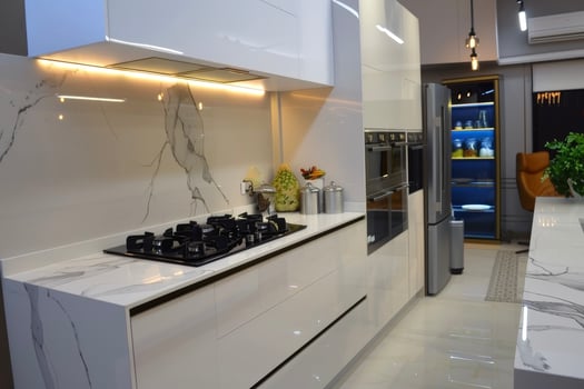 A modern kitchen with marble counter tops and white cabinets photo