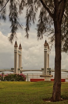 A stunning photogenic Kuala Terengganu drawbridge under a dramatic cloudy sky with structure featuring twin towers and a modern design that nestled against the ocean below. photo