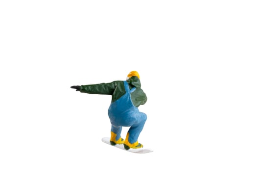 Miniature figurine depicting a snowboarder in mid-motion isolate on white background with clipping path photo