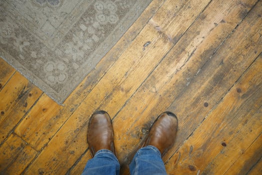 Stylish Brown Boots Placed on a Beautiful Wooden Floor and Cozy Rug photo