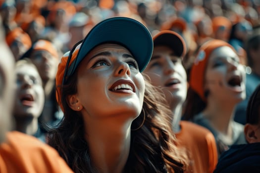 A woman with a blue hat and sunglasses is smiling at a crowd of people photo