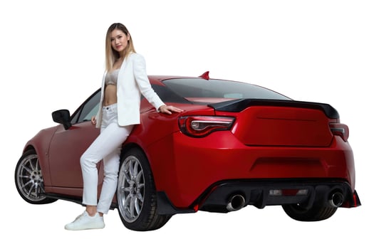 A photograph of a slender woman in a white suit standing beside a red, luxury sports car. photo