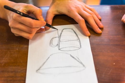 woman hands drawing a draft of a future clay cup photo