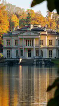 Majestic mansion reflected in serene waters surrounded by lush greenery in a tranquil setting photo