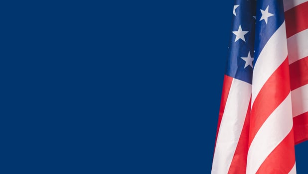 The American flag is against a blue background photo