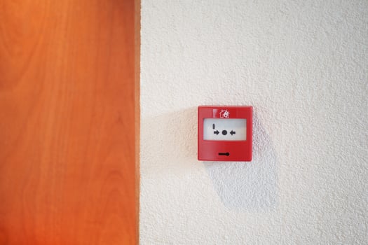 Red fire alarm button on wall , photo