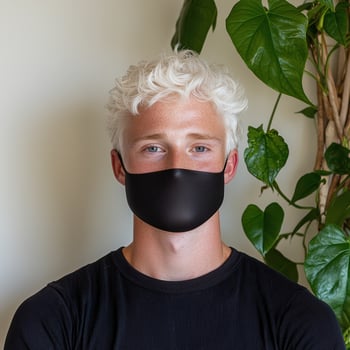 Young man with blonde hair wearing a black face mask photo
