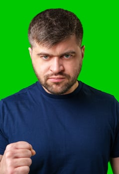 Assertive man making a fist against a bright green backdrop photo