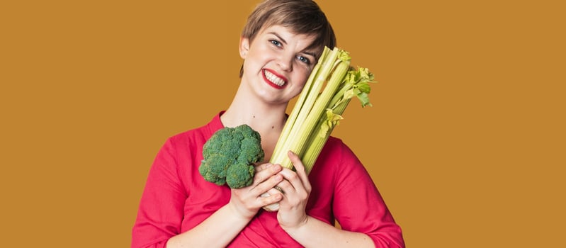 Smiling slender Caucasian girl with green vegetables in her hands, free space. Organic vegetables. photo