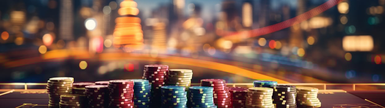 Stacks of casino chips on a gaming table with blurred city lights in the background photo