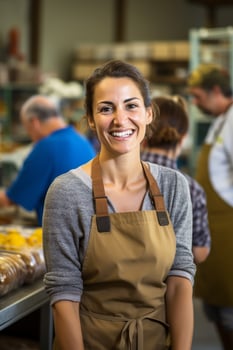 Smiling woman in apron working in kitchen photo