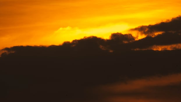 Beautiful sunset time lapse in orange sky with fluffy clouds. photo