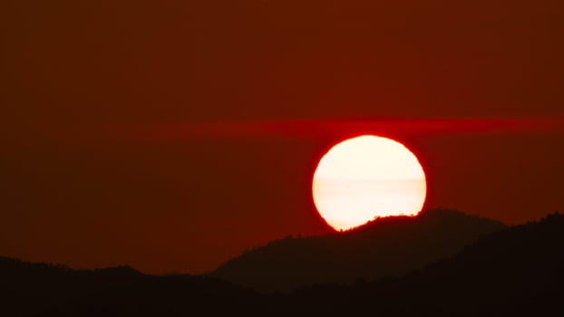 Timelapse shot of a beautiful sunrise over the horizon with an orange winter sky. Close-up of the sunrise photo