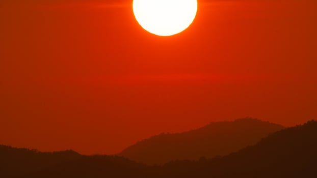 Timelapse shot of a beautiful sunrise over the horizon with an orange winter sky. Close-up of the sunrise. photo