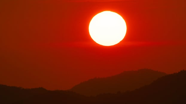 Timelapse shot of a beautiful sunrise over an orange winter sky. Close-up of the sunrise. Morning dawn landscape. photo