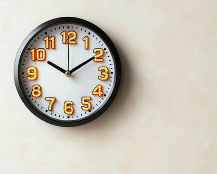 Modern wall clock with illuminated numbers showing the time photo