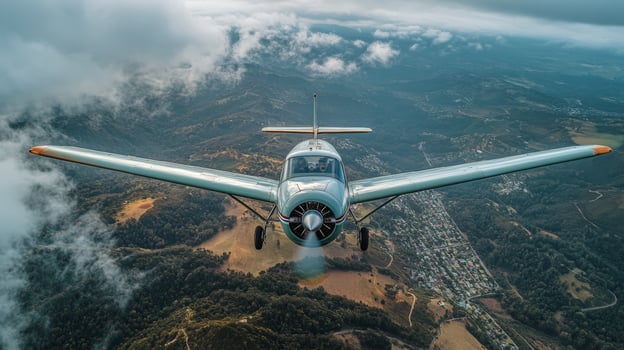 Unique aerial view of a vintage aircraft flying over scenic landscape with clouds and mountains photo