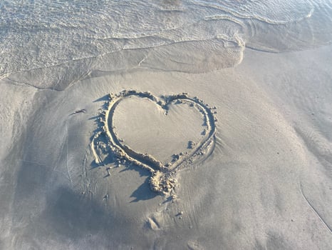Drawing a heart in the sand. A heart is drawn on the beach photo