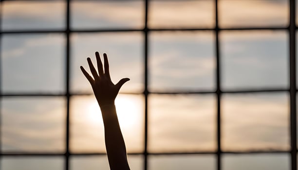 Silhouette of a Hand Reaching Towards the Setting Sun photo