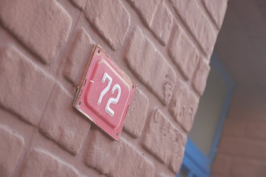 The charming House Number 72 is featured prominently on a textured wall photo