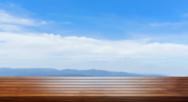 Front view of empty wooden table, sky and mountains background. photo