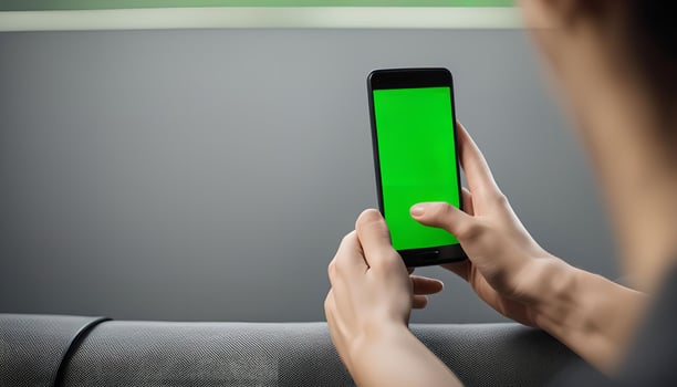 Person Holding a Smartphone With a Green Screen photo