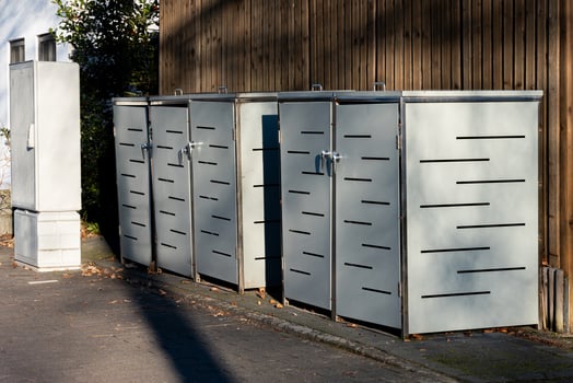 Modern metal storage units line a city street during daylight photo