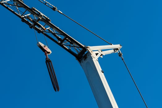 Crane against a clear blue sky at a construction site photo