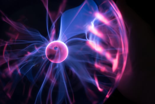 Hands holding plasma light ball on black background photo