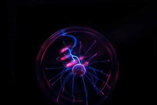 Hands holding plasma light ball on black background photo
