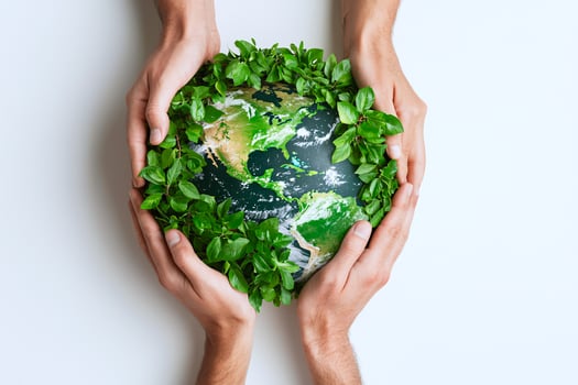 A globe of green leaves held by diverse hands, symbolizing global cooperation and environmental unity photo