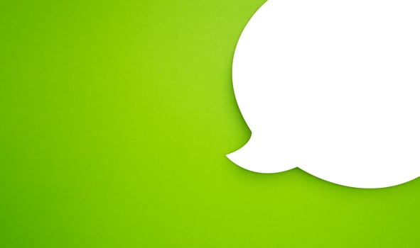 A blank white speech bubble part over a light green background photo