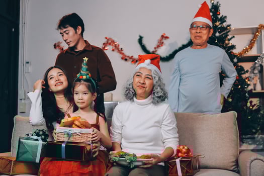 Asian family with christmas gifts on couch photo