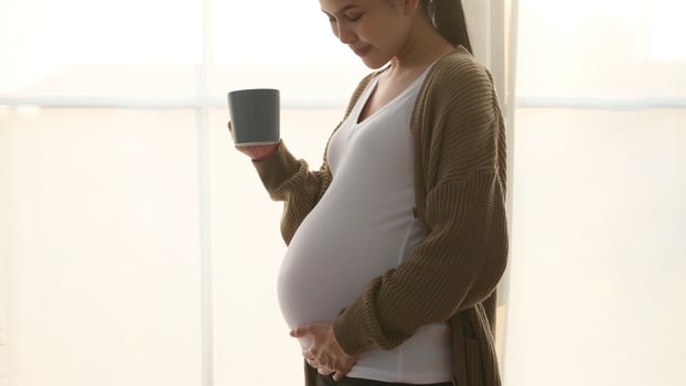 Expecting Mother Enjoying a Warm Drink in Cozy Room at Home photo