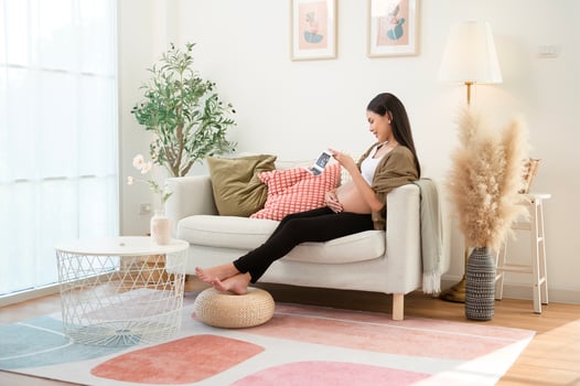 Pregnant woman holding ultrasound picture in living room at home photo