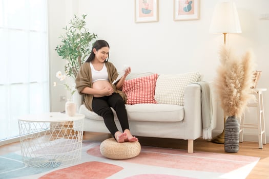 Pregnant woman holding ultrasound picture in living room at home photo