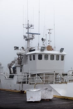 Fishing vessel in a foggy misty morning at Harbor photo