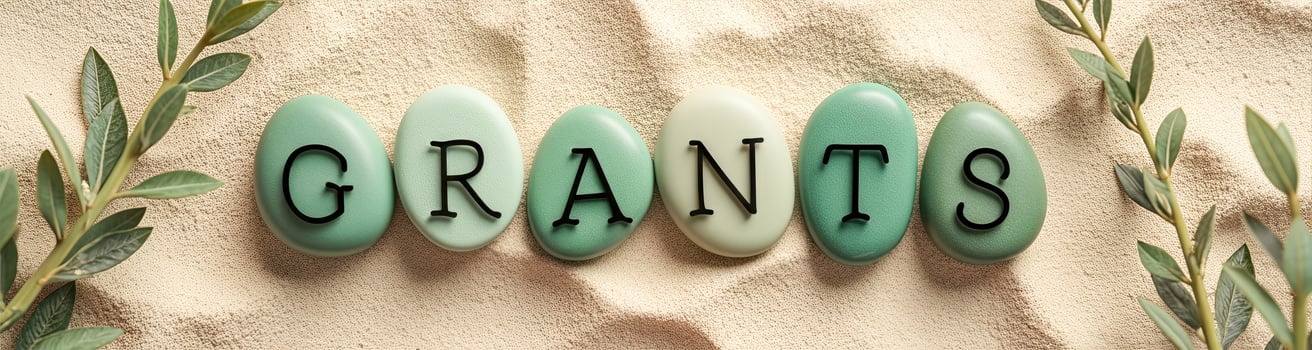 green stones spell out grants on beige surface photo