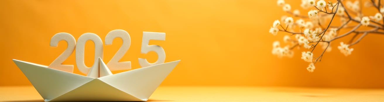 white origami boat carries the numbers 2025 against a yellow background. photo