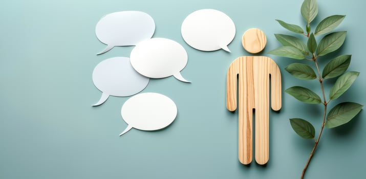 wooden figurine with speech bubbles green leaves photo